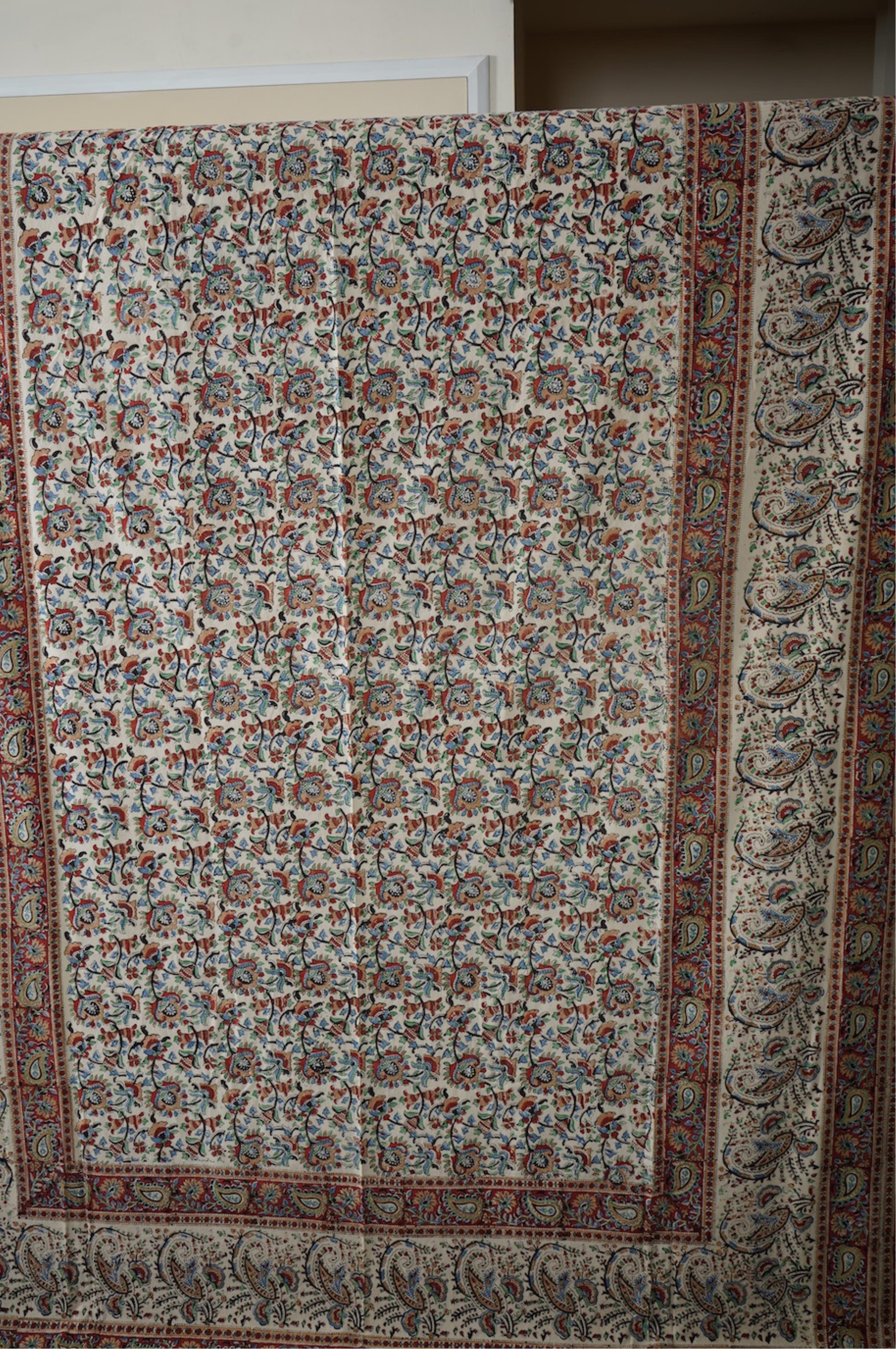 Two late 20th century large Indian block printed cotton bedcovers. One printed with brown borders, the other with brick red borders, both with large central panels designed in a classical Indian floral vining design. Bro